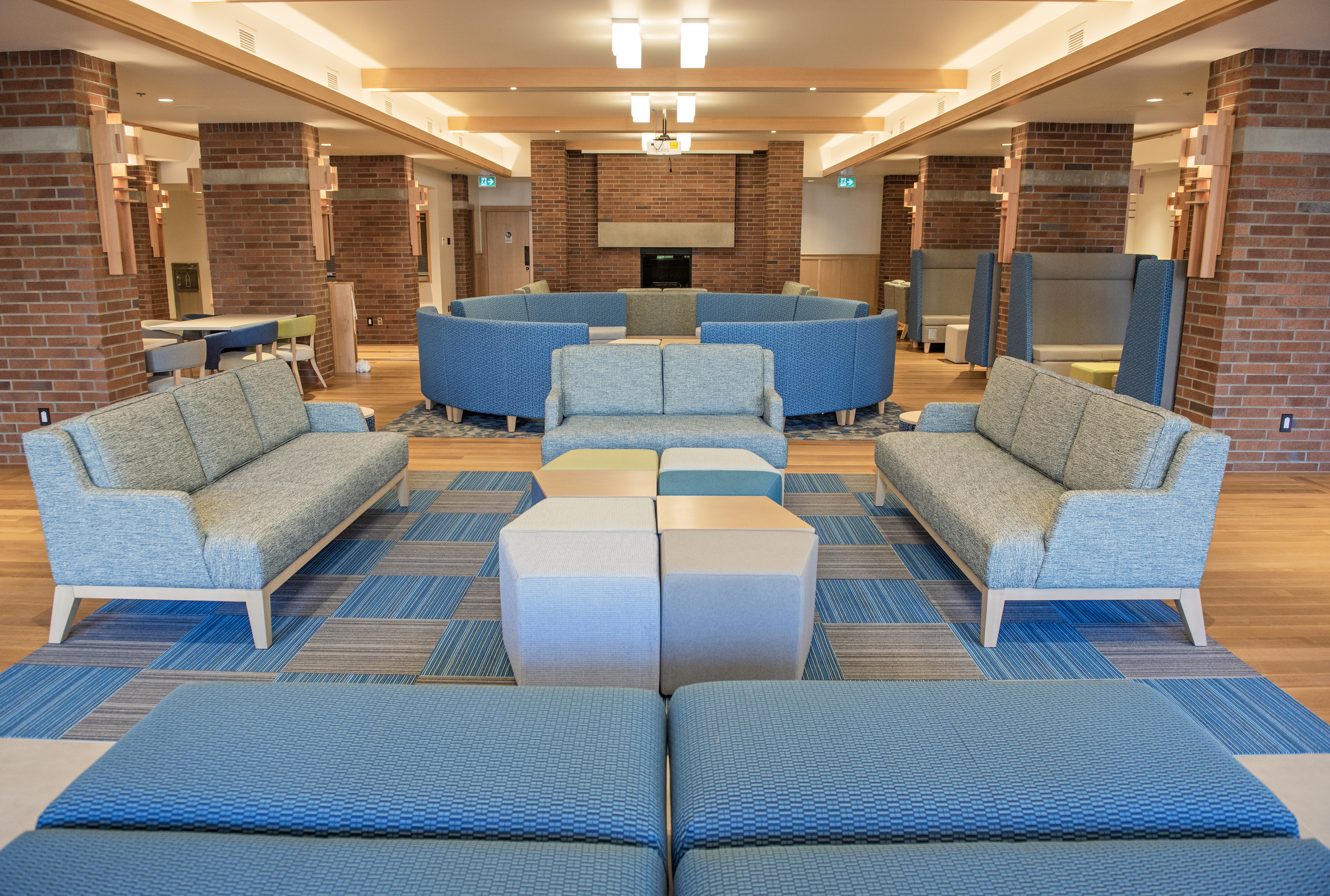 Indoor shot student commons, showing empty chairs and a fireplace.